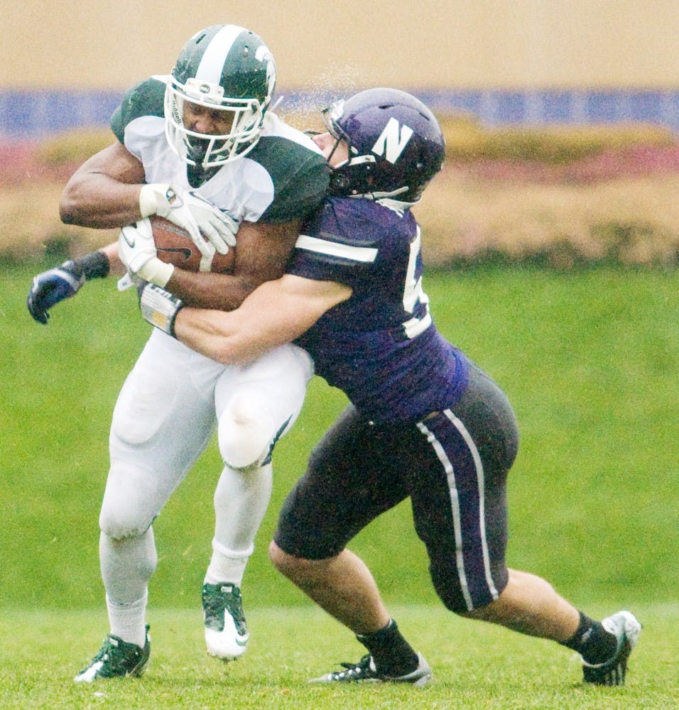 Junior running back Edwin Baker attempts to break a tackle by Northwestern linebacker Bryce McNaul. The Spartans defeated the Wildcats, 31-17, Saturday afternoon at Ryan Field, in Evanston, Ill. Justin Wan/The State News