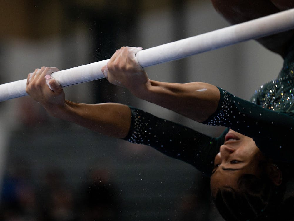 Jazlynn Chism, a freshman, competes upside down on the uneven bars with no grips during the MSU tri-meet at Jenison Field House on Sunday, Feb. 15, 2026.
