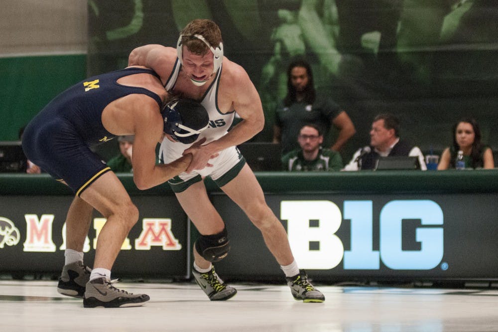 Sophomore 133-pounder Austin Eicher fights Wolverines 133-pounder Stevan Micic during Senior Day on Feb. 5, 2017 at Jenison Field House. The Spartan wrestlers were defeated by the Wolverines, 24-15. 