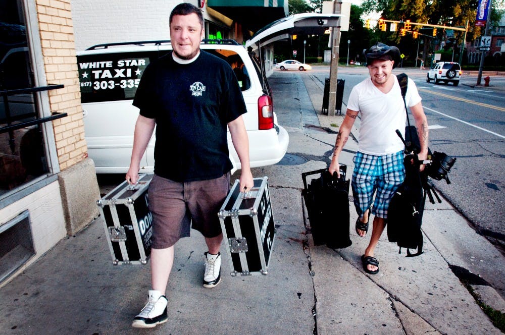 	<p>White Star Taxi driver Chris Fuller helps East Lansing DJ Donnie Herronen haul his gear into the basement bar that is Rick&#8217;s American Cafe. Herronen calls Fuller for a ride when he knows he will be drinking while he plays music for boozed up bar patrons.</p>