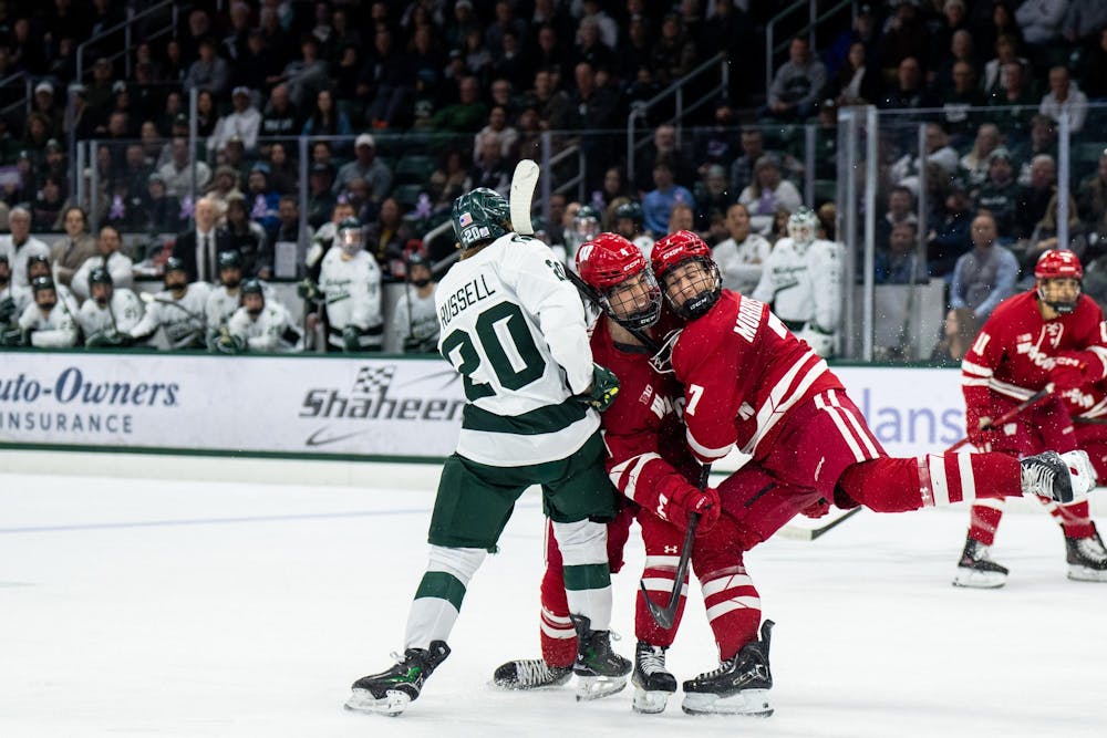 <p>Wisconsin forward Daniel Russell (20), Michigan State defenseman Ben Dexheimer (4), and Michigan State forward Gavin Morrissey (7) collide during the Michigan State versus  Wisconsin hockey game at Munn Ice Arena in East Lansing, Mich., on Saturday, Nov. 22, 2025.</p>