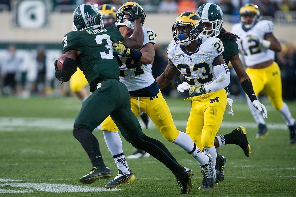 <p>Junior wide receiver Macgarrett Kings Jr. grabs Michigan defensive back Delonte Hollowell's helmet on Oct. 25, 2014, at Spartan Stadium. The Spartans defeated the Wolverines, 35-11. Julia Nagy/The State News</p>