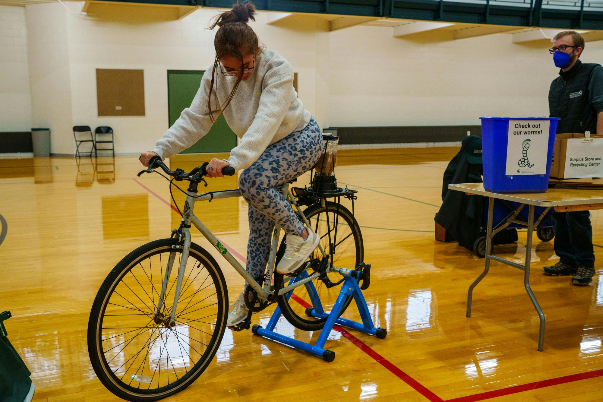 <p>A student uses the &quot;blender bike&quot; created by MSU Recycling, intended to use human power to create compost, at the 7th annual Exercise is Medicine Homecoming Walk at IM East on Oct. 12, 2022.</p>