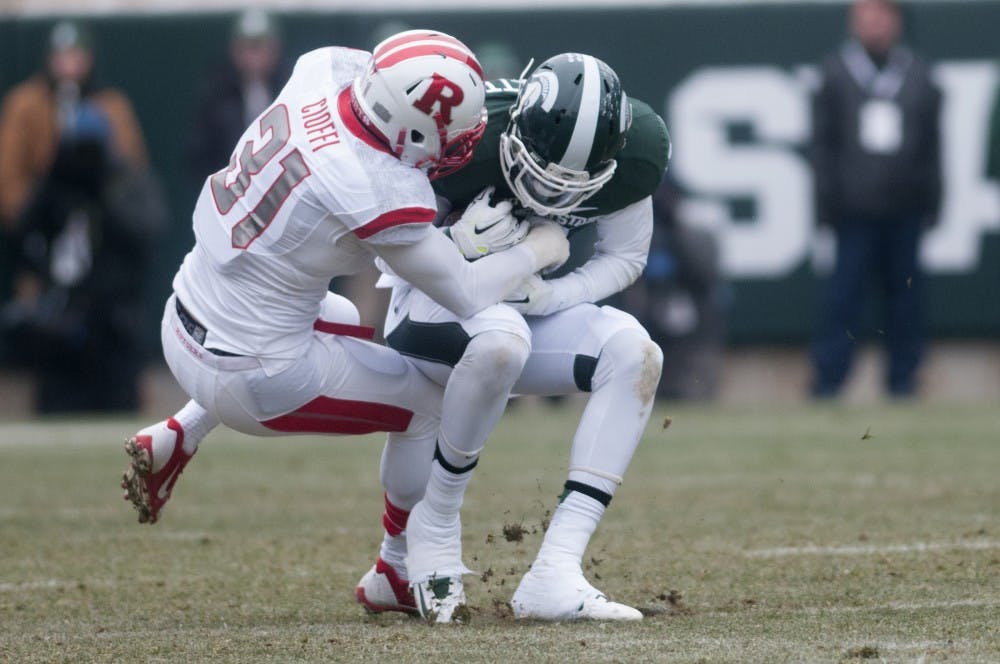 <p>Rutgers defensive back Anthony Cioffi tackles senior wide receiver Tony Lippett Nov. 22, 2014, during the game at Spartan Stadium. The Spartans defeated the Scarlet Knights, 45-3. Jessalyn Tamez/The State News </p>