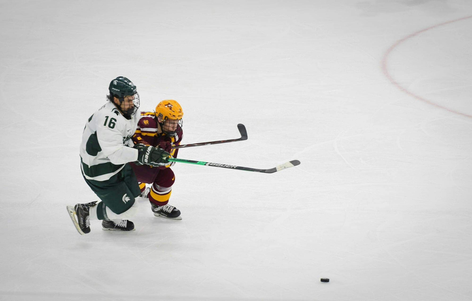 <p>Junior forward Brody Stevens (16) fights for the puck during the hockey game against Minnesota at the Munn Ice Arena on Jan. 10. The Spartans defeated the Golden Gophers 4-1. </p>