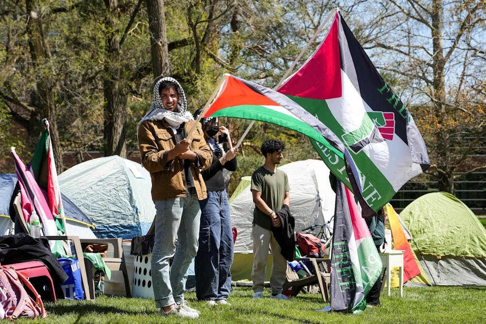 Michigan State University students wave Palestinian flags at the Gaza solidarity encampment in People’s Park on MSU’s campus on April 25, 2024.