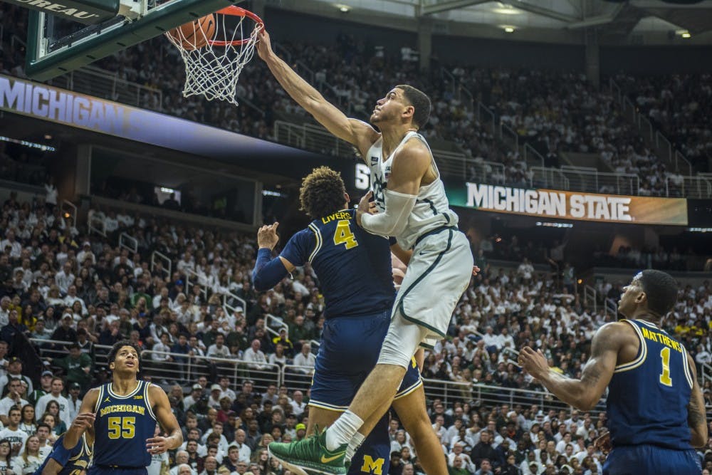 Senior forward Gavin Schilling (34) dunks the ball during the first half of the men's basketball game against Michigan on Jan. 13, 2018 at Breslin Center. The Spartan's led the first half, 37-34. (Nic Antaya | The State News)