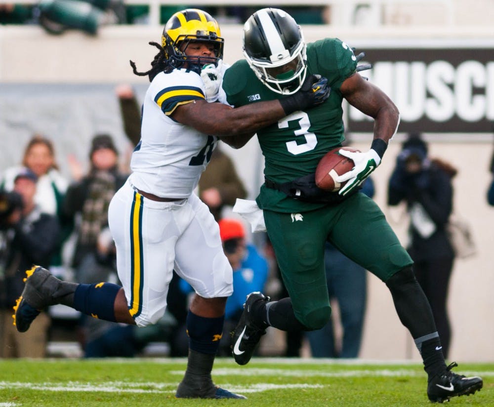 Senior running back LJ Scott (3) carries the ball during the game against Michigan at Spartan Stadium on Oct. 20, 2018.