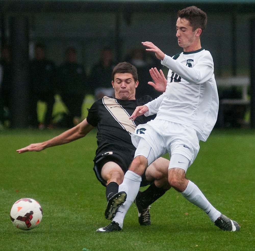 	<p>Sophomore midfielder Jay Chapman kicks the ball away from Oakland midfielder Matt DeLang during the game Oct. 16, 2013, at DeMartin Stadium at Old College Field. The Spartans defeated the Golden Grizzlies, 3-0. Danyelle Morrow/The State News</p>