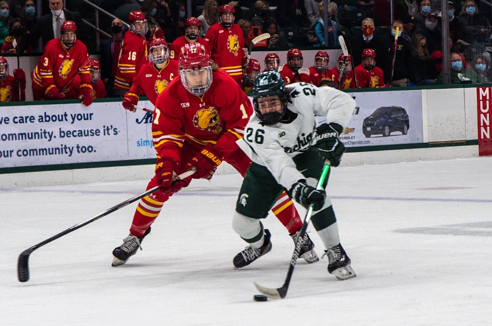 <p>Freshman right-wing Tanner Kelly (26) regains possession of the puck in the first period from a Ferris State player. The Spartans beat the Bulldogs, 2-0, in the final minutes of the game on Nov. 11, 2021. </p>