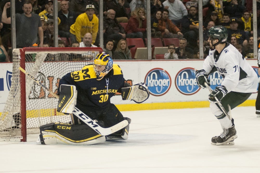 Freshman forward Logan Lambdin (71) shoots on Michigan goaltender Hayden Lavigne (30) during the third period of the men’s hockey game against the University of Michigan on Feb. 10, 2017 at Joe Louis Arena in Detroit. The Spartans were defeated by the Wolverines in an overtime shootout, 5-4. 