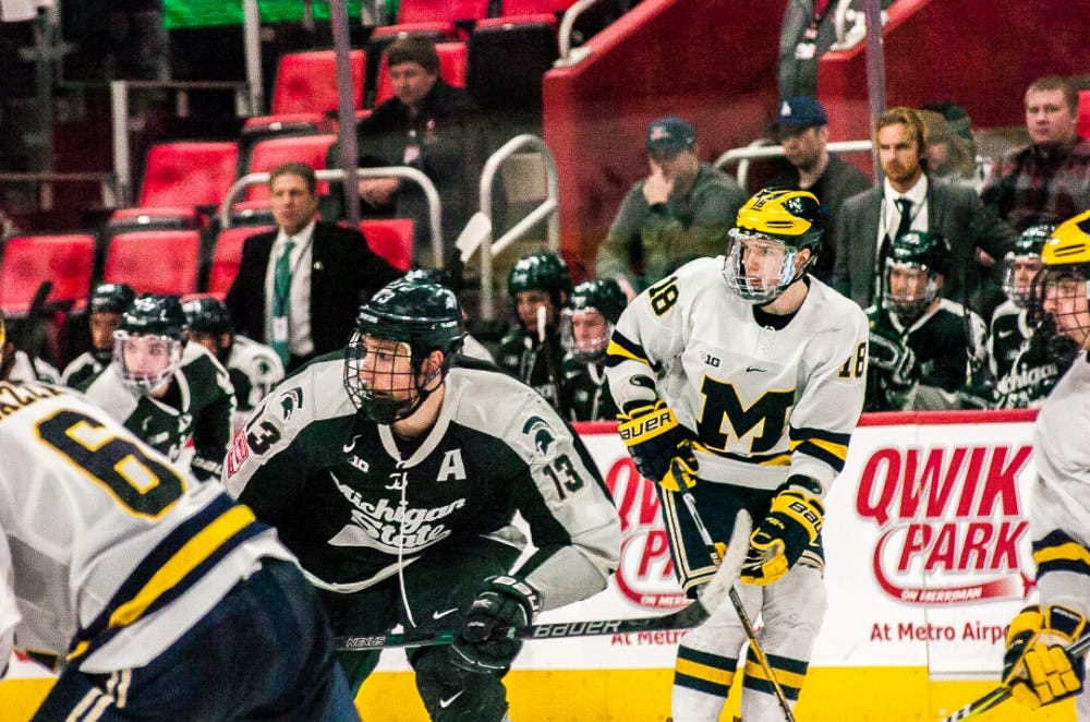 
Junior forward Brennan Sanford (13) looks for a pass followed closely by sophomore forward Adam Winborg (18) during the game against University of Michigan on Jan. 2, 2018, at Little Caesars Arena.  The Spartans fell 6-4 to the Wolverines. 

