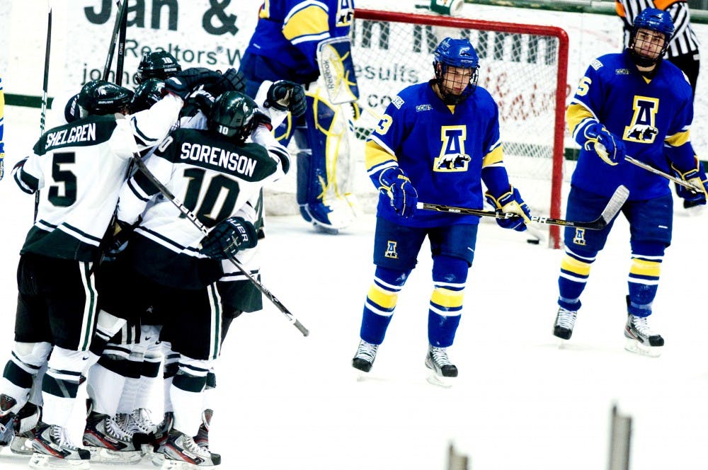 The spartans celebrate after a goal scored by freshman forward Brent Darnell Friday night at Munn Ice Arena. Darnell contributed to two of the three goals scored by MSU to cap a 3-2 victory in an overtime thriller over the Alaska nanooks. Aaron Snyder/The State News. 