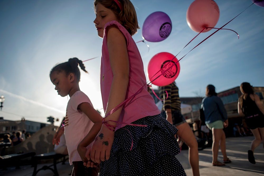 	<p>From left, Okemos resident Pannonica Gilmore, 7, and East Lansing resident Marie Adele Grosso, 8, walk with balloons in hand as Hundreds of residents crowded the 300 block of Albert Avenue, Saturday, April 27, 2013, during Taste of East Lansing. Justin Wan/The State News</p>