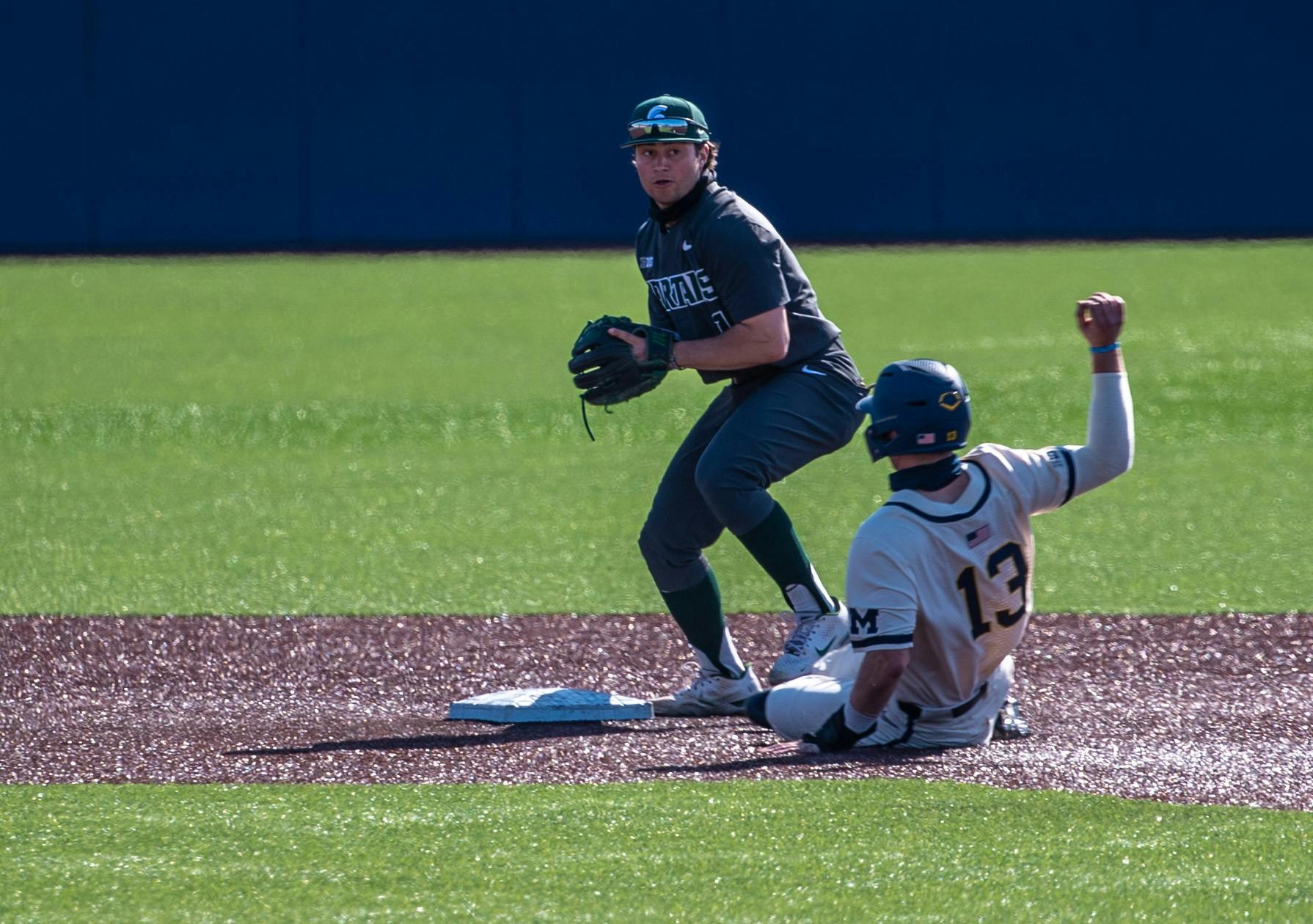 Freshman infielder Trent Farquhar (1) gets Michigan's Griffin Mazur out before throwing it to first, resulting in a double play. The Wolverines made a comeback in the ninth inning to top the Spartans 8-7 at Ray Fisher Stadium on Mar. 21, 2021.