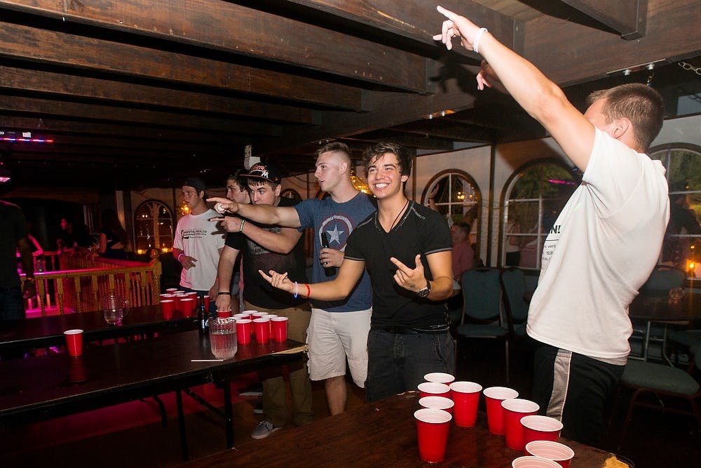 <p>Finance freshman Blake Nolan, left, and marketing freshman Jacob Fox play beer pong with water Sept. 10, 2014, at a College Night Freedom Fest party at The River Boat at Grand River Park, 2995 W Main Street, in Lansing. College Night parties are typically every other week for student and general admission 18 years and older. Erin Hampton/The State News</p>