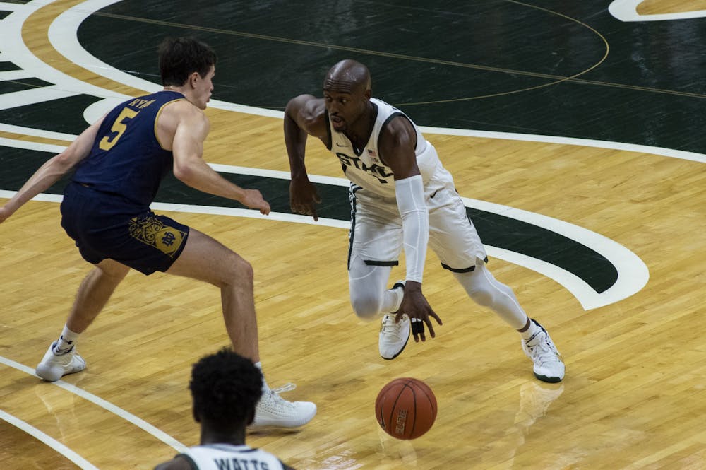 Graduate student guard Joshua Langford (1) dribbles the ball before passing it to freshman guard A.J. Hoggard in the second half. Michigan State triumphed over Notre Dame, 80-70, on Nov. 28, 2020. 