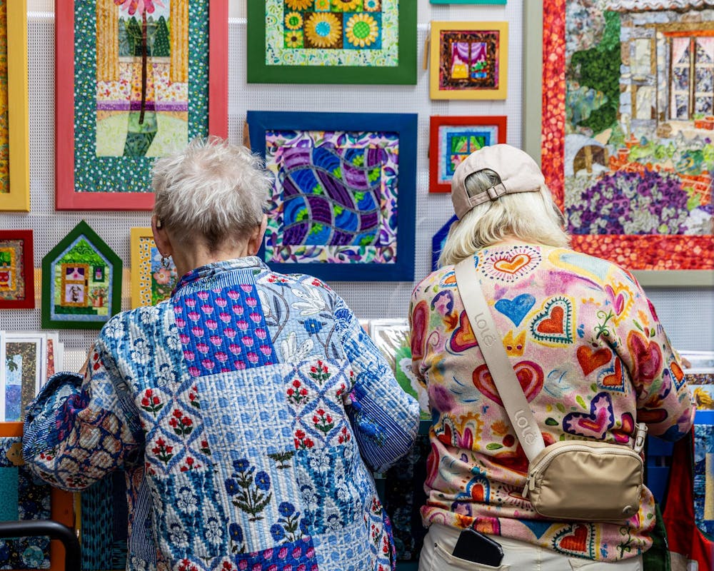 <p>Two customers look through art to purchase at the 63rd annual East Lansing Art Festival in East Lansing, Mich., on May 16, 2026.</p>