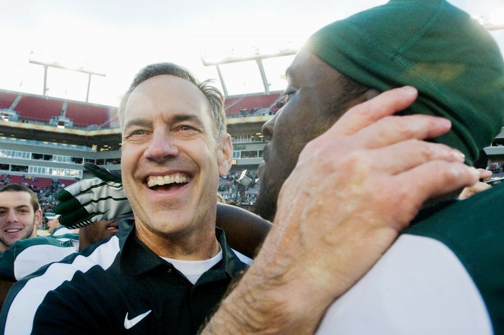 <p>Head coach Mark Dantonio hugs then-senior safety Trenton Robinson on Jan. 2, 2012, after the Outback Bowl at Raymond James Stadium in Tampa, Fla. The Spartans defeated the Georgia Bulldogs in triple overtime, 33-30. </p>