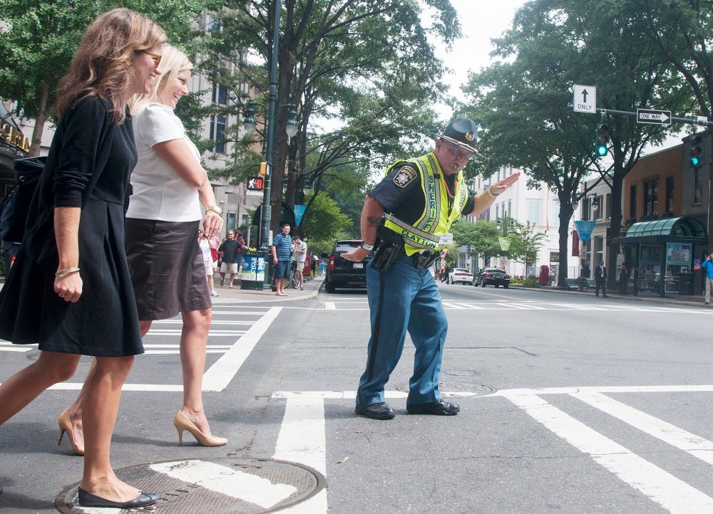 An officer from the Clayton County Sheriff's Dept., in Georgia, entertains people crossing the street while directing traffic on the corner of Tyron St. and 5th St. in downtown Charlotte, N.C., on Thursday, Sept. 6, 2012. The officer danced and blew his whistle to entertain people passing by or crossing the street. Samantha Radecki/The State News 