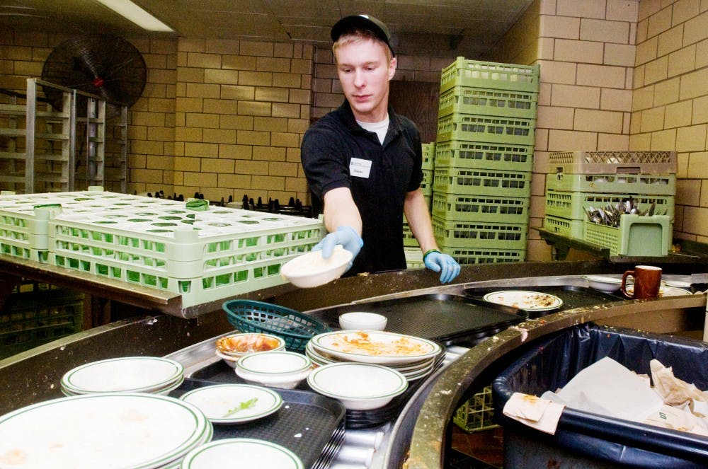 Fisheries and wildlife junior Steven Ripley sorts through the dishes produced by the dinner time rush in the cafeteria at Shaw Hall. Recently, an ASMSU representative brought a bill to meeting that would aim to eliminate unsanitary practices in the cafeterias. Anthony Thibodeau/The State News