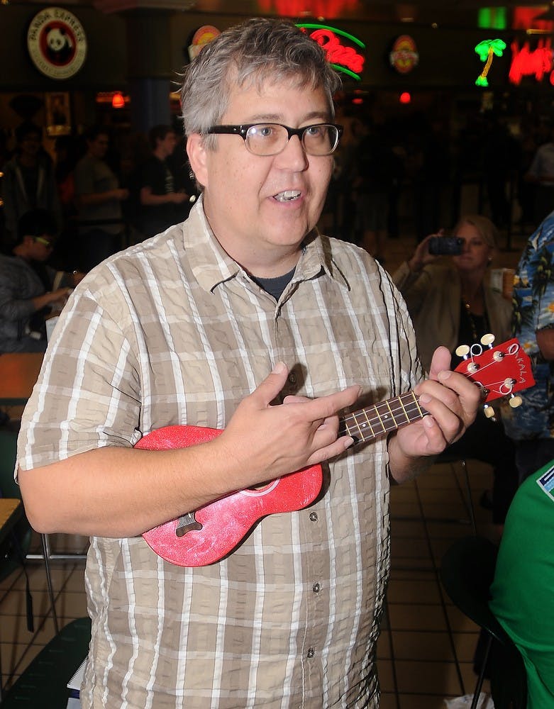 	<p>John French, a planetarium presenter at <span class="caps">MSU</span>, strokes his ukulele during the flashmob on Wednesday, Oct. 3rd, 2012, at the International Center. The Lansing Area Ukulele Group was there to promote the upcoming Ukulele Orchestra of Great Britain performance on Oct. 14 at the Wharton Center. Katie Stiefel/The State News</p>