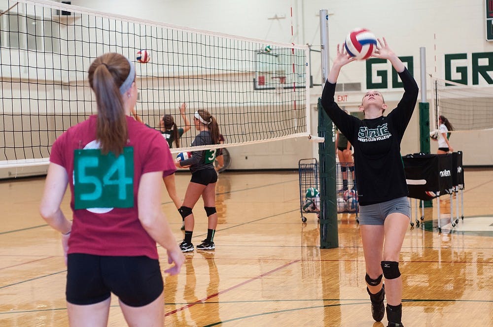 <p>Marketing freshman Jennifer Gerlach, left, warms up with prenursing sophomore Hannah Schroll during club volleyball try-outs on Sept. 23, 2014, at IM Sports-West. Schroll and Gerlach played volleyball together for three years before coming to college. Jessalyn Tamez/The State News</p>