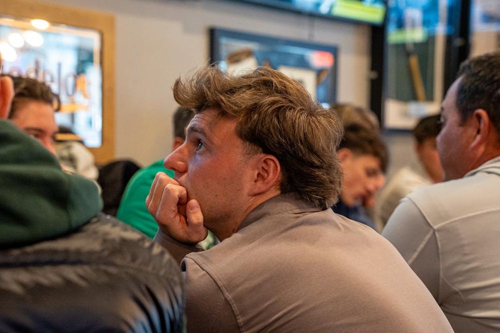 <p>A spectator at Lou and Harry's Bar and Grill in East Lansing, MI watches MSU hockey take on the Wisconsin Badgers on March 28, 2026. The Spartans fell to the Badgers in overtime, 4-3.</p>