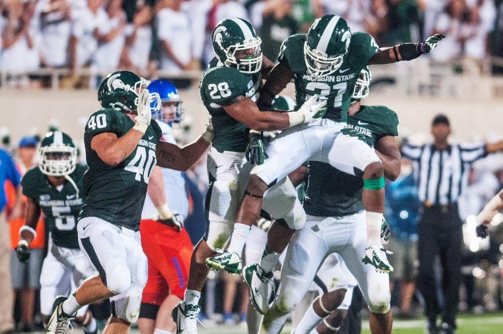 Junior cornerback Darqueze Dennard celebrates with teammates after making a strong defensive play Friday night, Aug. 31, 2012 at Spartan Stadium. Dennard recorded a total of 5 tackles as the Spartans defeated Boise State 17-13 in MSU's home opener game. Adam Toolin/The State News