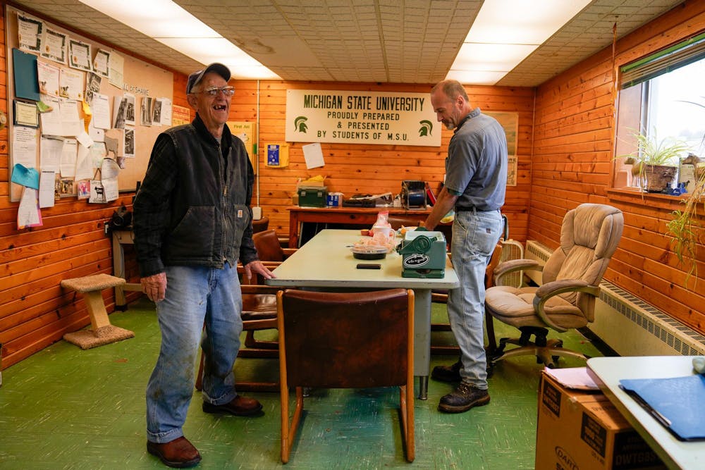 Duane Reum, 88, of Lansing, laughs with his coworker Randy Bontrager at the end of his shift at the Dairy Cattle and Research Center in Lansing on Sept. 28, 2023. While Bontrager eats during his lunch break at 11:30 a.m., Reum is ready to head home after his morning shift at the farm. 