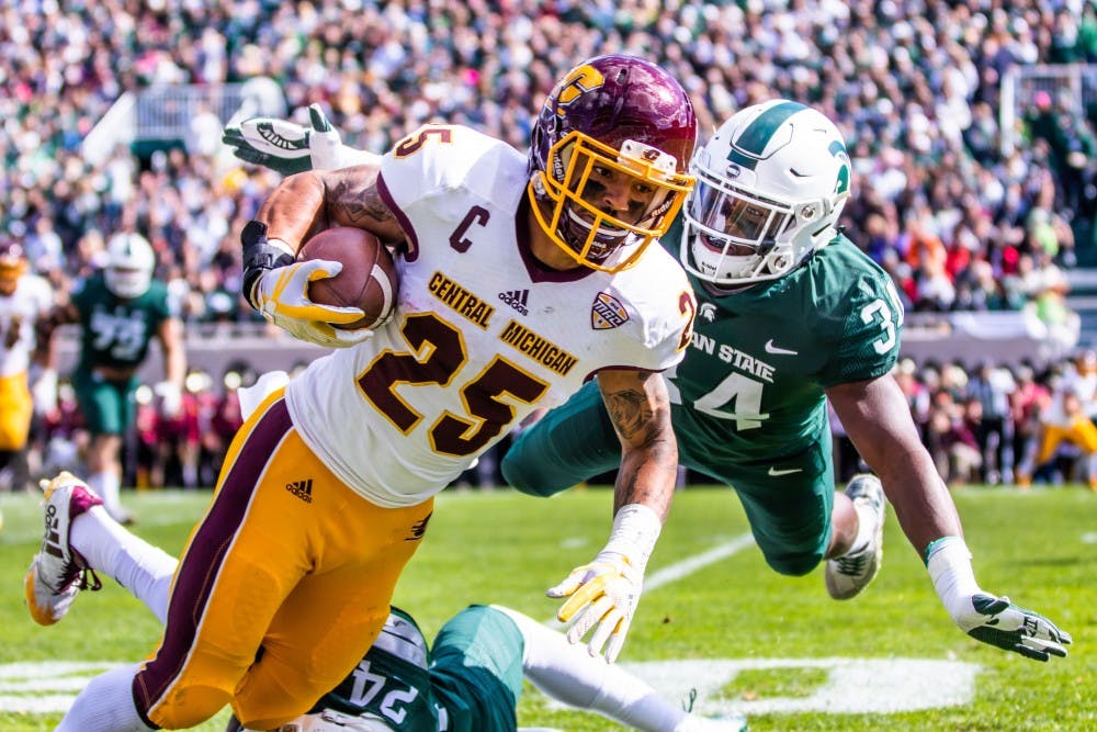 <p>Sophomore linebacker Antjuan Simmons (34) dives to push Central Michigan wide receiver Devon Spalding (25) during the game on Sept. 29, 2018 at Spartan Stadium. The Spartans defeated the Chippewas, 31-20.</p>