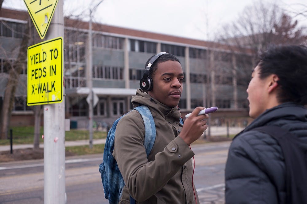 <p>Journalism freshman Jequcory Davis, left, decides to make the pledge after being convinced by marketing and sales sophomore and Phi Kappa Psi member John Ko Nov. 17, 2014, at the rock on Farm Lane. Pi Kappa Psi asked people to sign their names on the rock as a way to bring awareness to the "It's On Us" campaign against sexual assault. Erin Hampton/The State News</p>