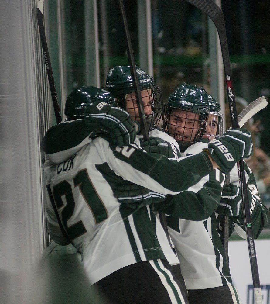 	<p>Freshman forward Joe Cox, 21, senior forward Dean Chelios, 16, and redshirt freshman defender Brock Krygier celebrate the first Spartan goal against Princeton on Nov. 29, 2013, at Munn Ice Arena.The Spartans defeated Princeton, 4-1. Danyelle Morrow/The State News</p>