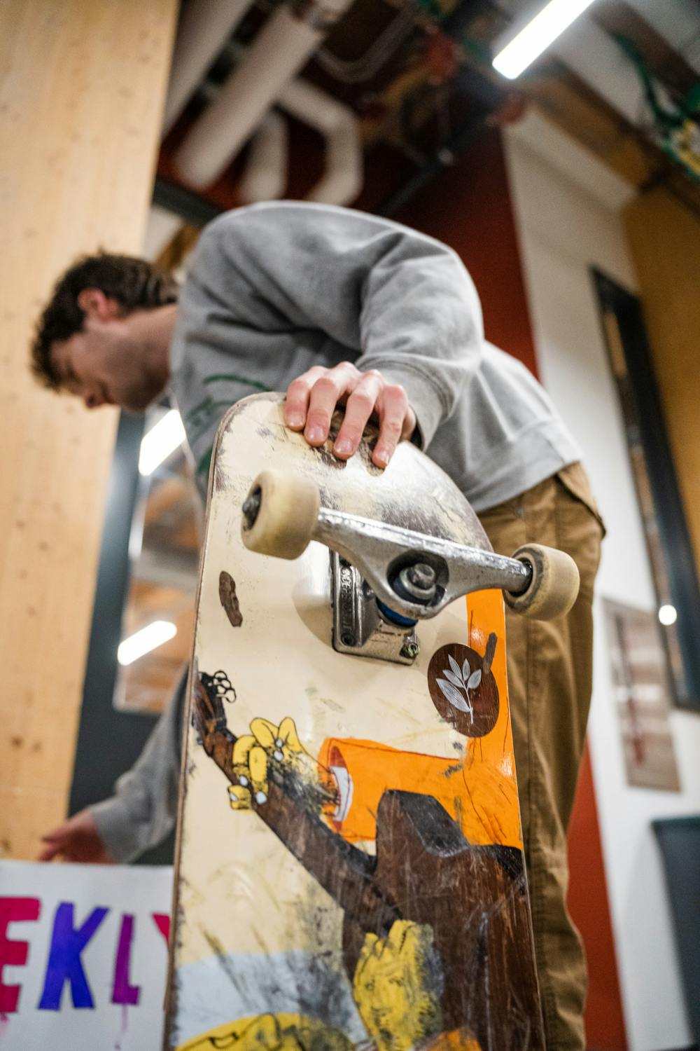 <p>MSU Skateboarding Club Member shows off his board while setting up signs during Springticipation on Jan. 17, 2023.</p>