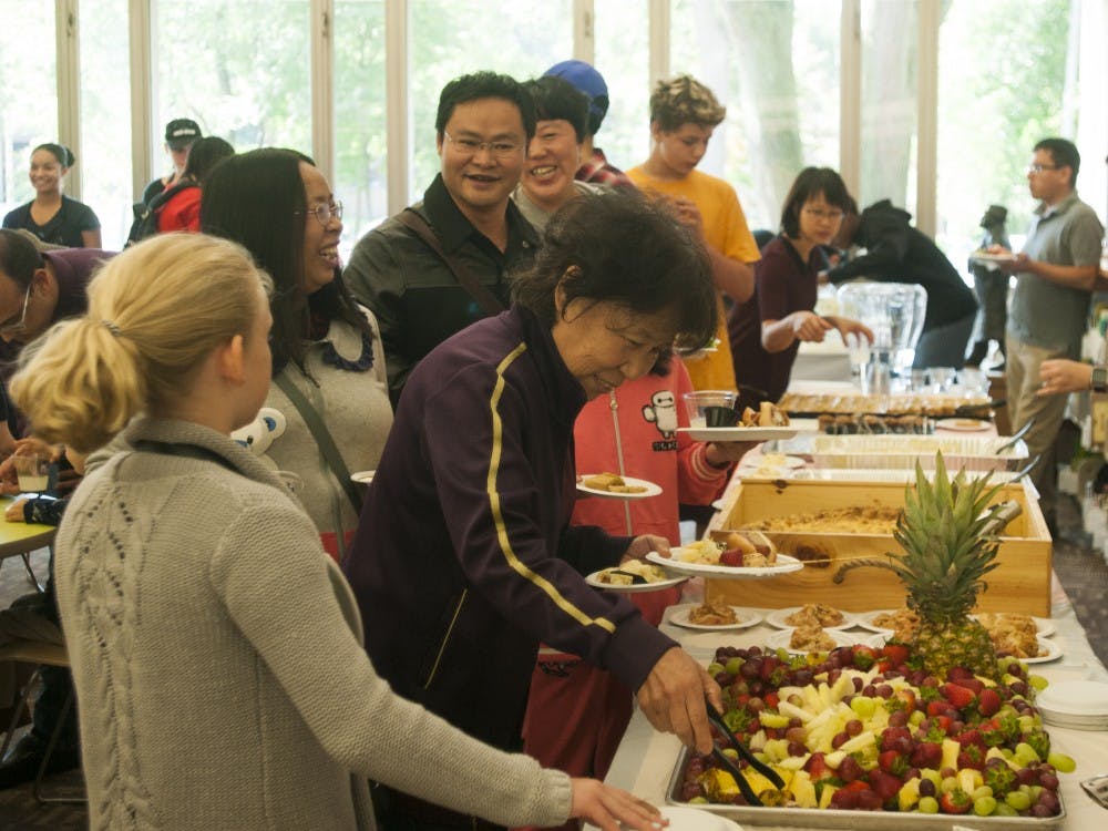 Guests go through the food line during East Lansing Welcomes the World on Oct. 2, 2016 at the East Lansing Public Library at 950 Abbot Road.  The event was for international students and families to come and meet people in their community. 