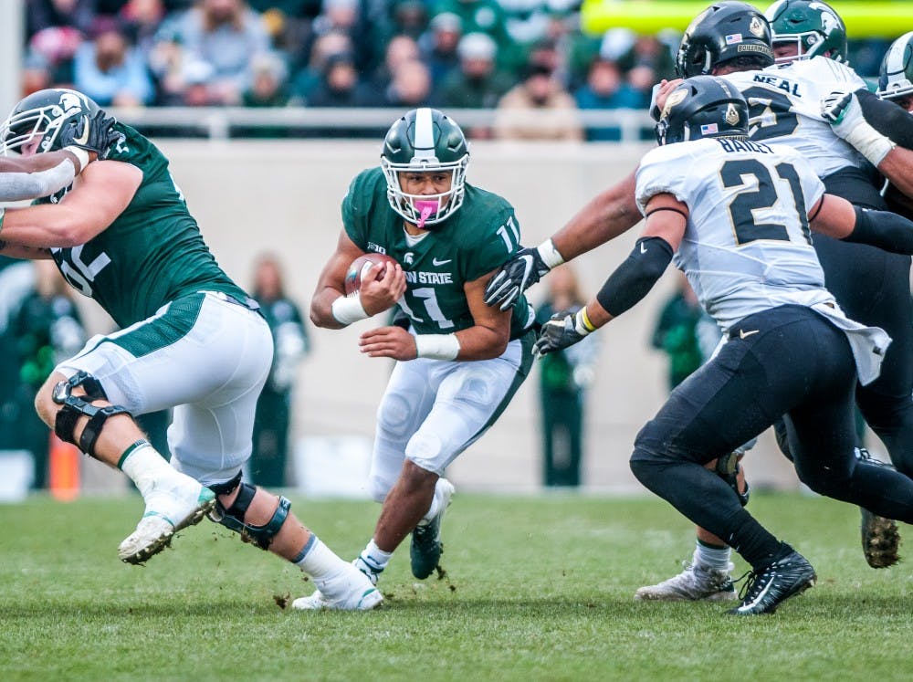 Sophomore running back Connor Heyward (11) runs through a gap in the defense during the game against Purdue on Oct. 27, 2018 at Spartan Stadium. The Spartans lead the Boilermakers 13-6 at half.
