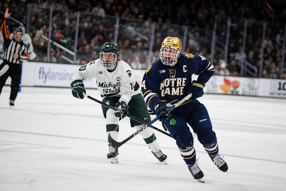 <p>Tommi Männistö, a junior forward (10) for the Michigan State University hockey team, and Michael Mastrodomenico, a senior defenseman for the University of Notre Dame hockey team, rush toward the puck at Munn Ice Arena in East Lansing, Michigan, on Friday, Feb. 20, 2026.</p>