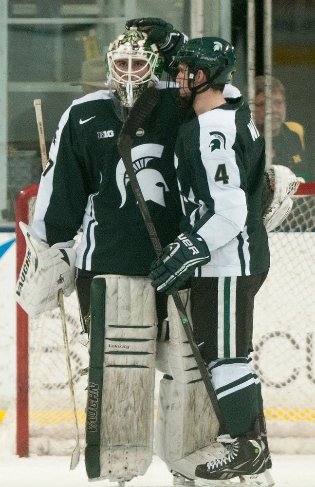 <p>Sophomore defenseman Travis Walsh talks with senior goaltender Will Yanakeff following the game against Michigan on March 7, 2014, at Yost Ice Arena in Ann Arbor, Mich. The Spartans were defeated by the Wolverines, 7-1. Danyelle Morrow/The State News</p>