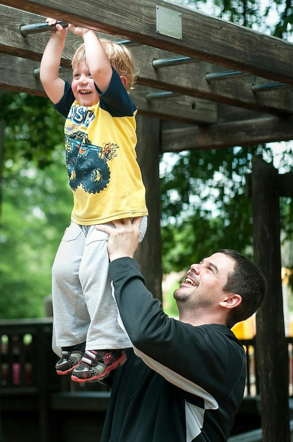	<p>Perry, Mich., resident Mike Rains helps his son Mikey, 2, across the monkey bars June 16, 2013, at Patriarche Park. Celebrating Father&#8217;s Day at the park where he used to play as a kid, Mike Rains Sr. said he was glad be able to bring his son there. Danyelle Morrow/The State News</p>