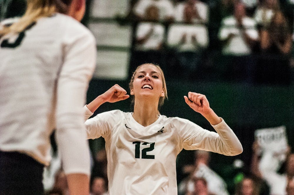 Senior setter Rachel Minarick (12) reacts to a successful play during the game against Michigan on Oct. 18, 2017 at Jenison Fieldhouse. The Spartans secured a 3-1 win against the Wolverines. 