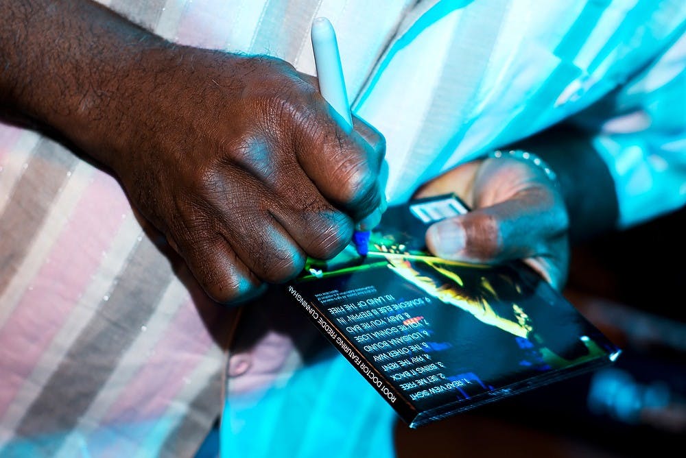 <p>Root Doctor bassist and vocalist James Williams signs autographs June 21, 2014, at the Jazz Festival on Albert Rd. Hayden Fennoy/The State News</p>