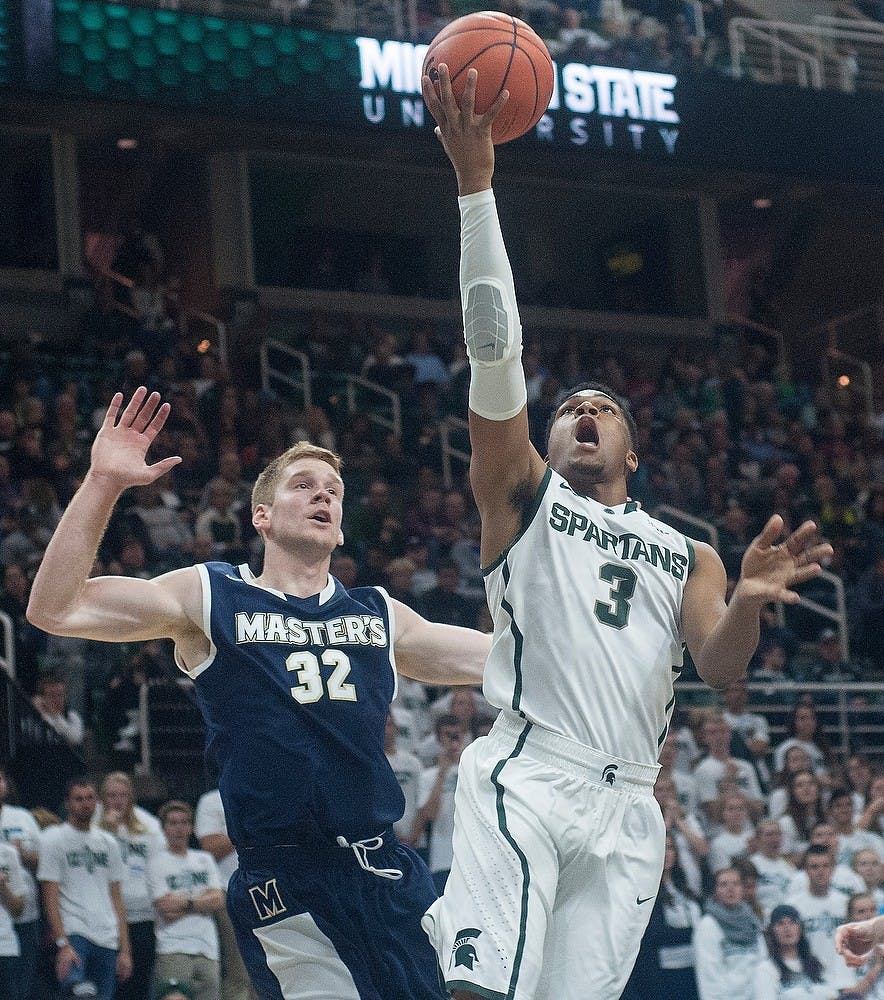 <p>Sophomore guard Alvin Ellis III lays the ball up as The Master's College guard Russell Byrd defends him on Nov. 3, 2014 at the Breslin Center. The Spartans defeated the Mustangs, 97-56. Aerika Williams/The State News.</p>