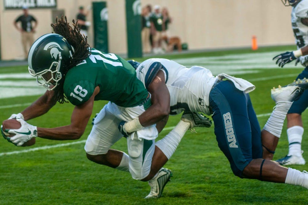 <p>Senior wide receiver Felton Davis III (18) catches the ball during the game against Utah State on Aug. 31 at Spartan Stadium. At halftime the Spartans were leading 20-14.</p>