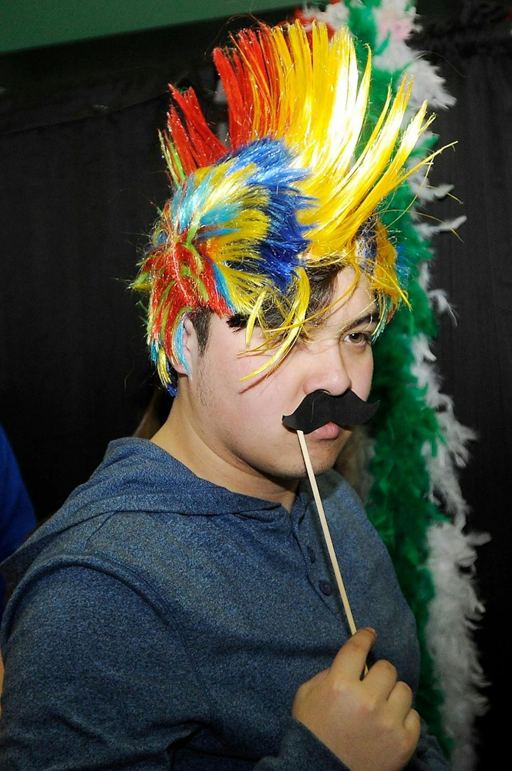 <p>Hospitality Business freshman Michael Hugh puts on a costume to enter the photo booth at the Relay For Life fundraiser March 28, 2014, at Breslin Center. All proceeds from the event will go towards the American Cancer Society. Allison Brooks/The State News</p>