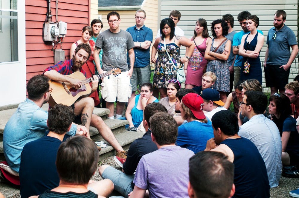 People gather to watch Chicago-based singer/songwriter Owen perform, Thursday, June 28, 2012 at the Hariet Brown house located at 1124 Snyder Rd.  The house is occupied by four MSU students who host musical acts for fans to come enjoy.  Adam Toolin/The State News
