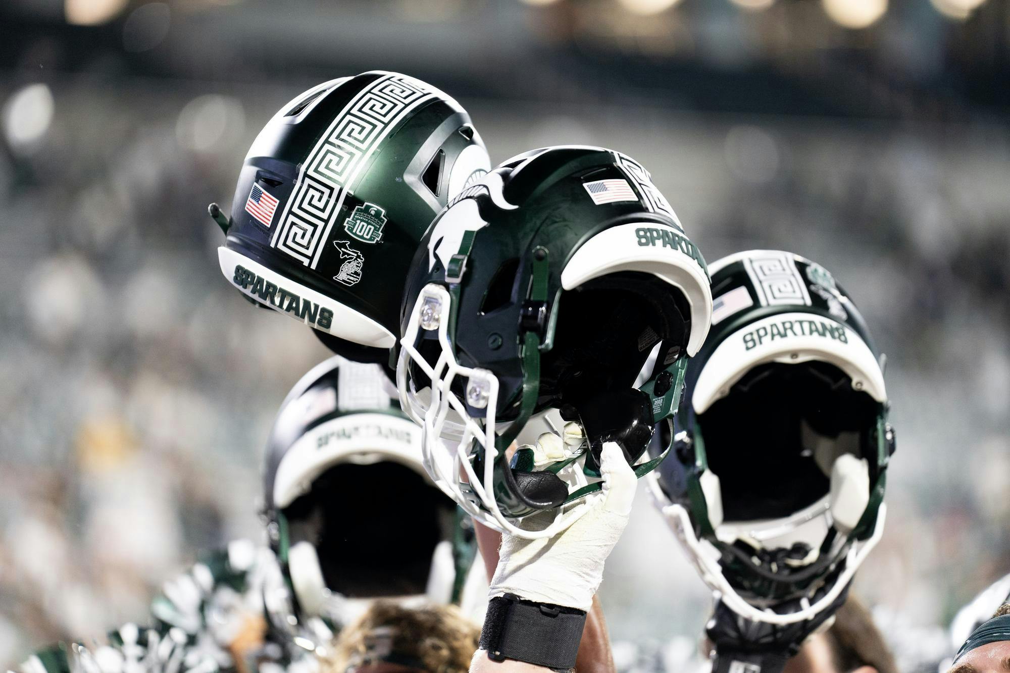 <p>Spartan helmets held aloft in celebration following the conclusion of Michigan State's night game against Central Michigan Universy on Sept. 1, 2023. Michigan State won their home opener 31-7.</p>