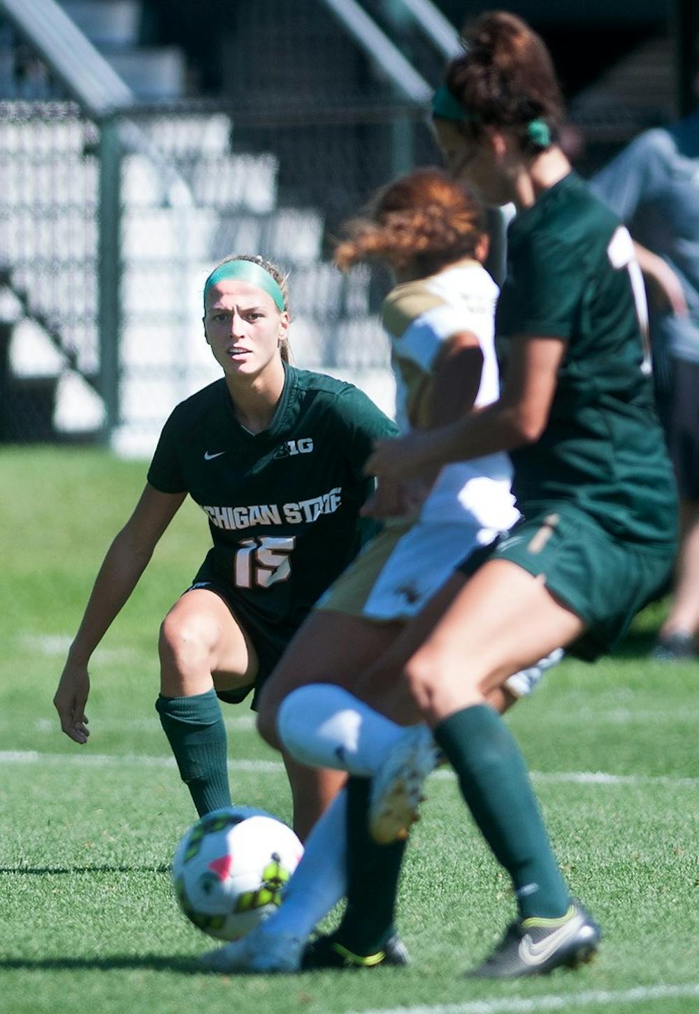 <p>Freshman forward Jamie Cheslik kicks the ball passed Western midfielder Rachel Chaney and teammate senior midfielder Megan Marsack Sunday, during a game against Western Michigan University at DeMartin Stadium at Old College Field. The Spartans defeated the Broncos, 3-2. Aerika Williams/The State News</p>