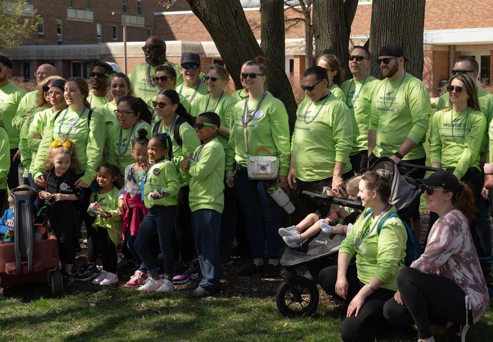 A group of Morrie's Okemos Ford employees pose for a picture at the Out of the Darkness 5k walk at People's Park on April 14, 2024. "A lot of their lives have been touched by suidcide, that's why we're here," said Lonnie Przybylinski, the dealership's general manager.