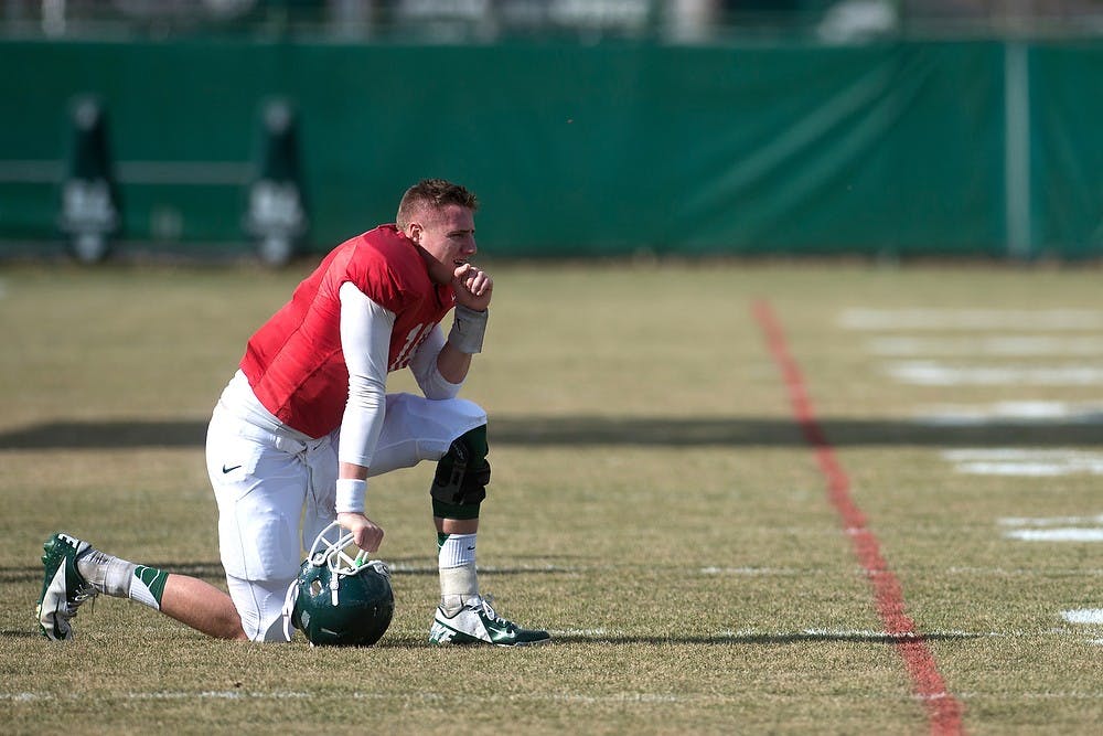 <p>Junior quarterback Connor Cook takes a break during football practice April 8, 2014, at the practice field outside Duffy Daugherty Football Building. Julia Nagy/The State News</p>