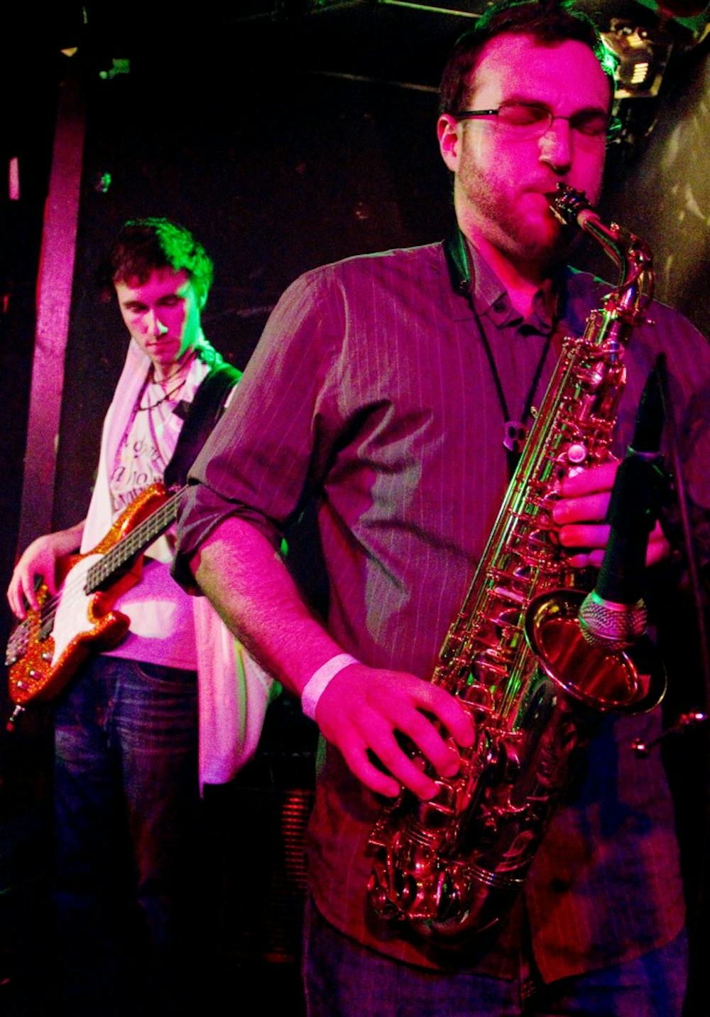 Bassist Spencer Ralph and saxophonist Royce Phillips Jr. of the band East Harvest play at Mac's Bar, 2700 E. Michigan Ave. Saturday night. The East Lansing-based group had a CD release party to showcase their first album. Derek Berggren/The State News